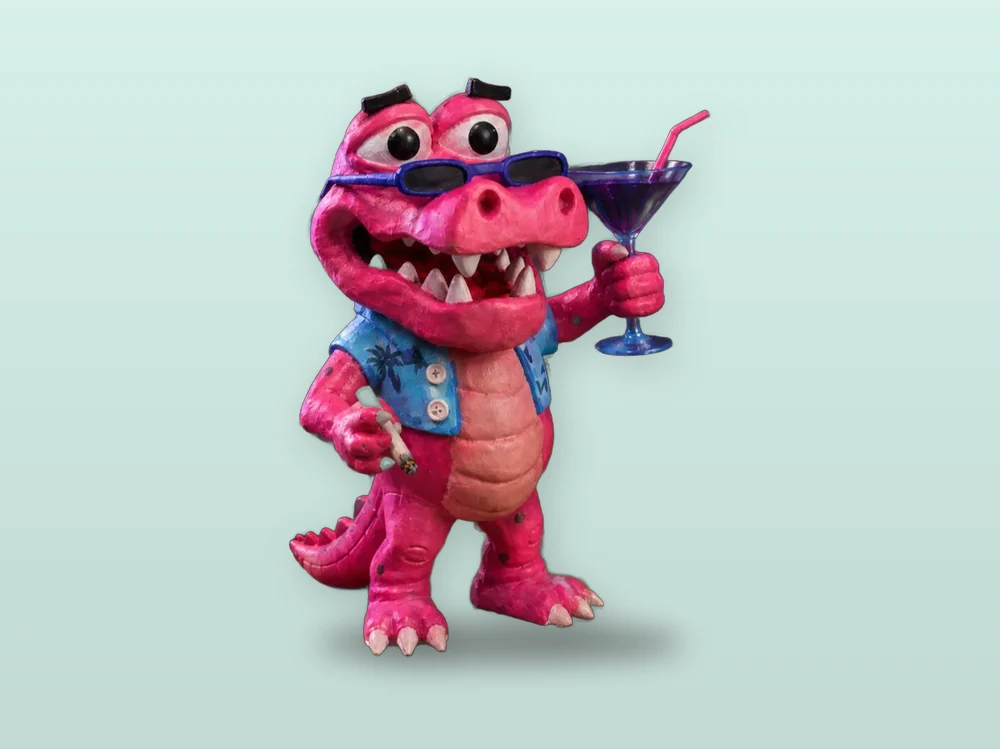 Hand-painted pink alligator figurine in sunglasses holding a cocktail