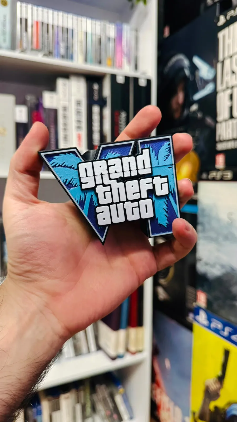 Hand holding a blue GTA VI logo AirPods case cover