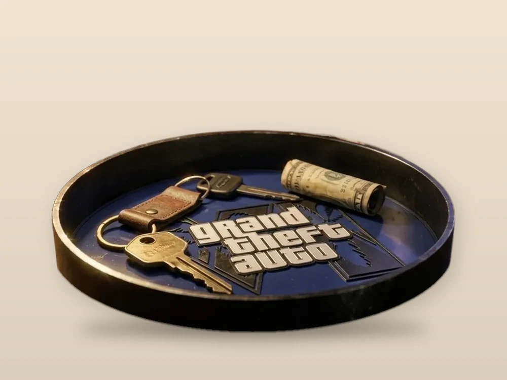 Round black valet tray with a Grand Theft Auto logo holding keys and cash